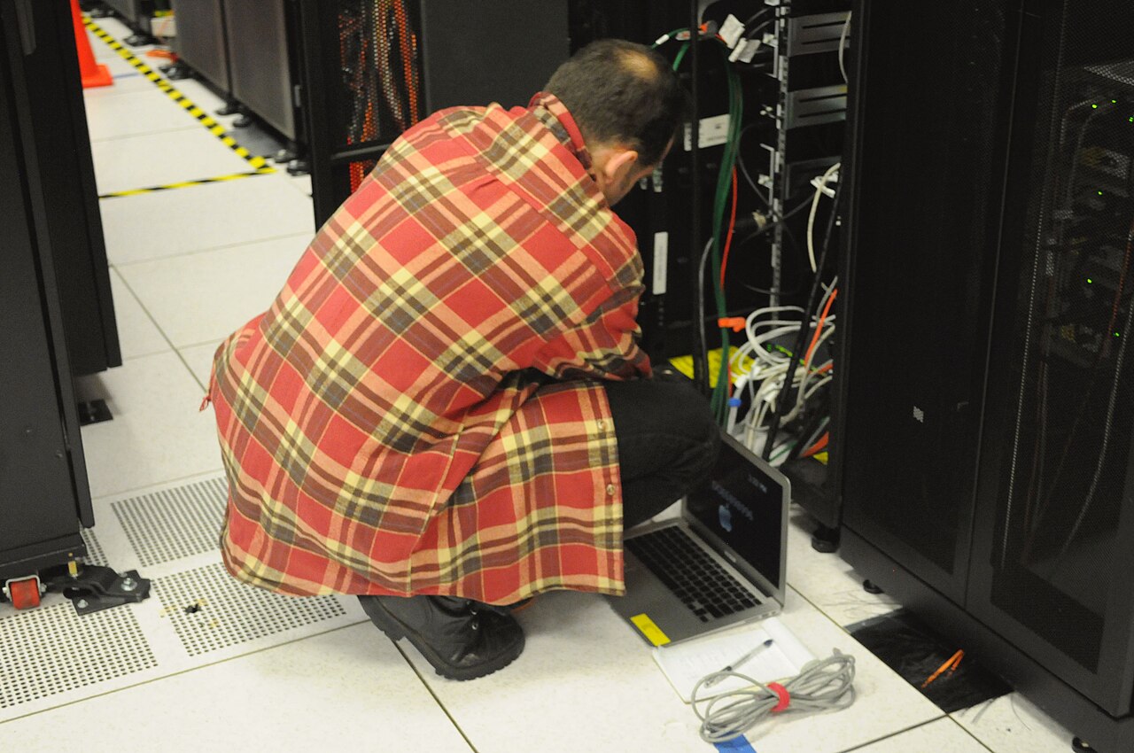 Data center safety technician working at a server rack